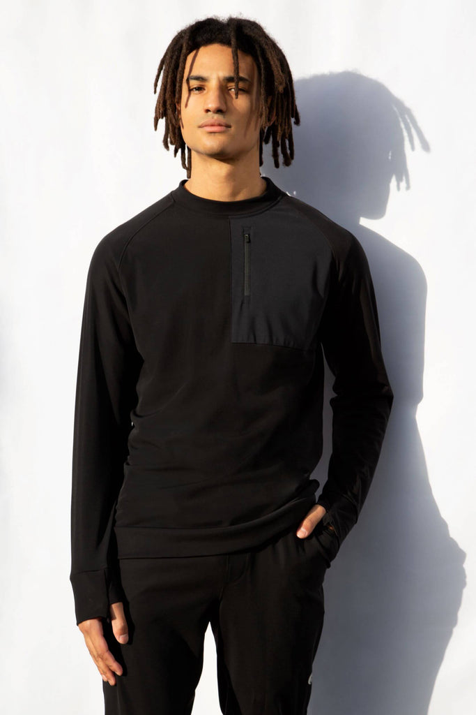 Full length shot of a man modelling the Belu Life Bergen Fleece. A black fleece jumper designed for activewear 